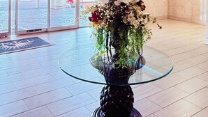 Un vestíbulo con una mesa de vidrio, una lámpara colgante y vistas al exterior.