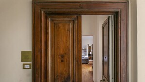 A wooden door with a plaque on the wall. - Family stay in Trastevere (Rome)