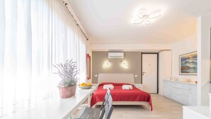 A modern bedroom with a bed, bedside table, and a potted plant. - Rena Bianca Mono - 5 mins from the beach, WiFi, AC (Olbia)