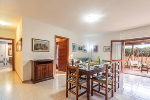 Un coin repas avec une table et des chaises en bois, un buffet et des tableaux encadrés accrochés au mur.