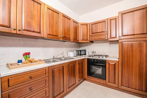 A kitchen with wooden cabinets, a microwave, a stove, and a toaster.