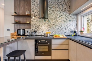 A modern kitchen with a large island, built-in appliances, and a window providing a view. - Villa Gigi with private Pool, Višnjan, Croatia (Višnjan)