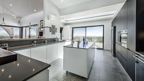 Una cocina moderna con una isla central, ventanas amplias y vistas al paisaje.