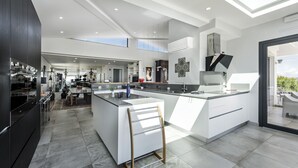 Una cocina moderna con una isla central, un comedor y un ventanal grande que proporciona luz natural.