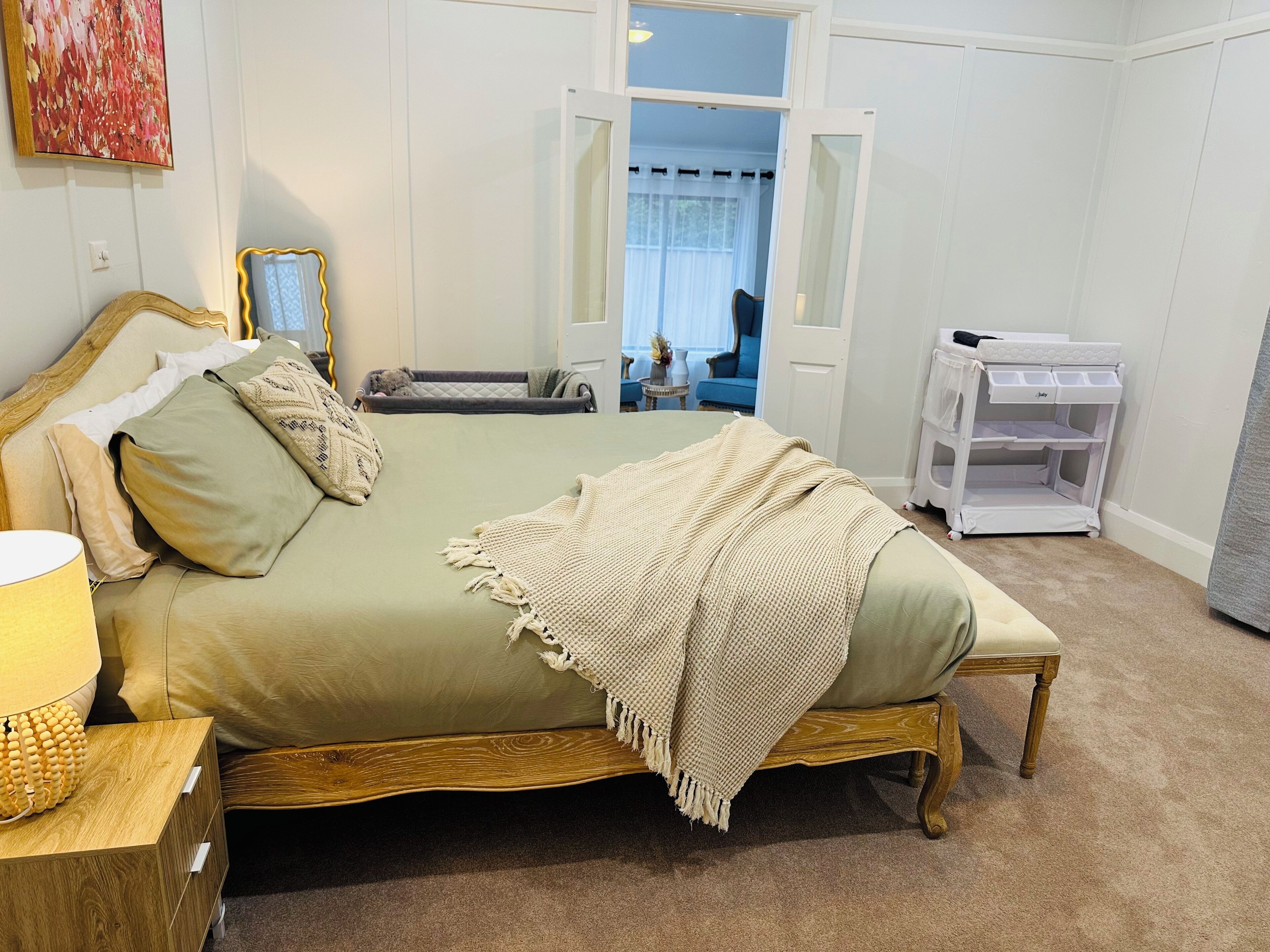 Une chambre à coucher comprenant un lit, une table de chevet et un meuble de rangement.