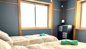 Ein Hotelzimmer mit zwei Betten, einem Schminktisch und einem Fenster.