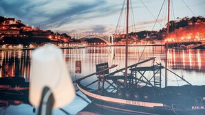 A waterfront view with a bridge, boats, and a cityscape. - GuestReady - Cathedral Design Apartments - Sé (Porto)