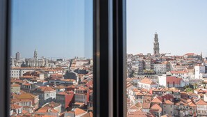 A cityscape with a prominent tower, dense residential buildings, and a clear sky. - GuestReady - Cathedral Design Apartments - Sé (Porto)