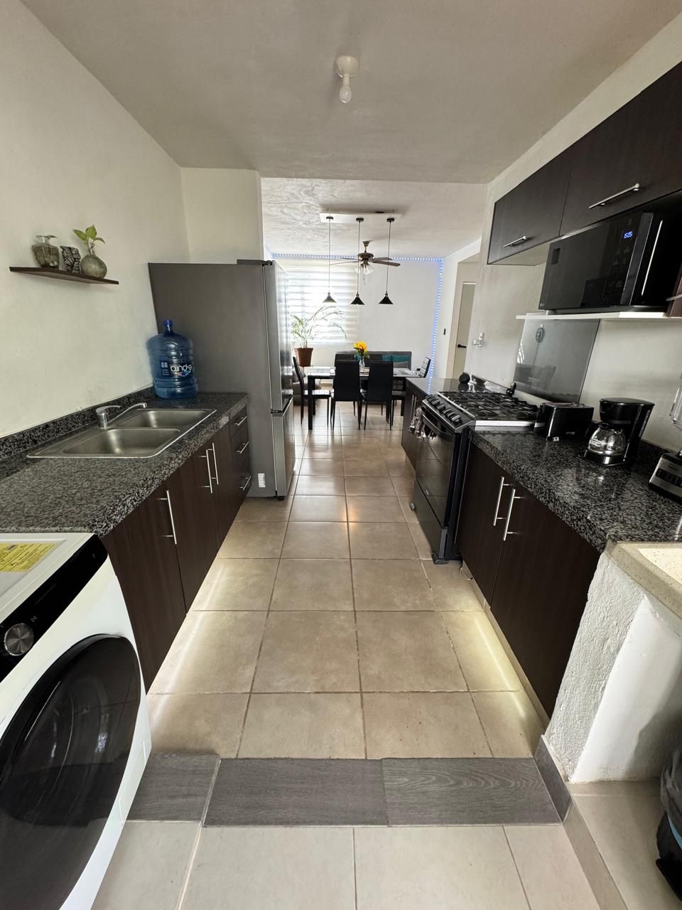 A modern kitchen with granite countertops, stainless steel appliances, and a central island.