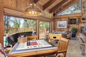 Un intérieur en bois avec un jeu d’échecs sur une table, un jeu de fléchettes et un tableau au mur.