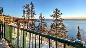 A balcony with a view of a lake, surrounded by tall evergreen trees. - Two Harbors Superior Lakefront 2BR | Pool | Hot Tub & Sauna | EV Charger (Two Harbors)