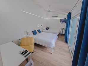 A modern hotel room with a bed, bedside tables, a desk, and a chair.