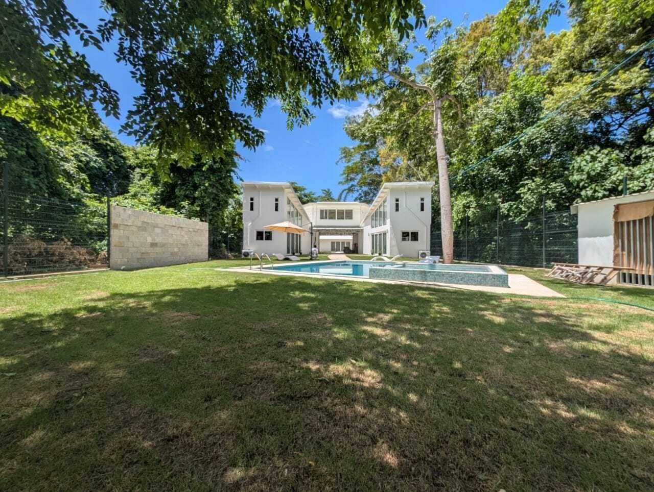 Een groot, tweelaags huis met een zwembad in de achtertuin.
