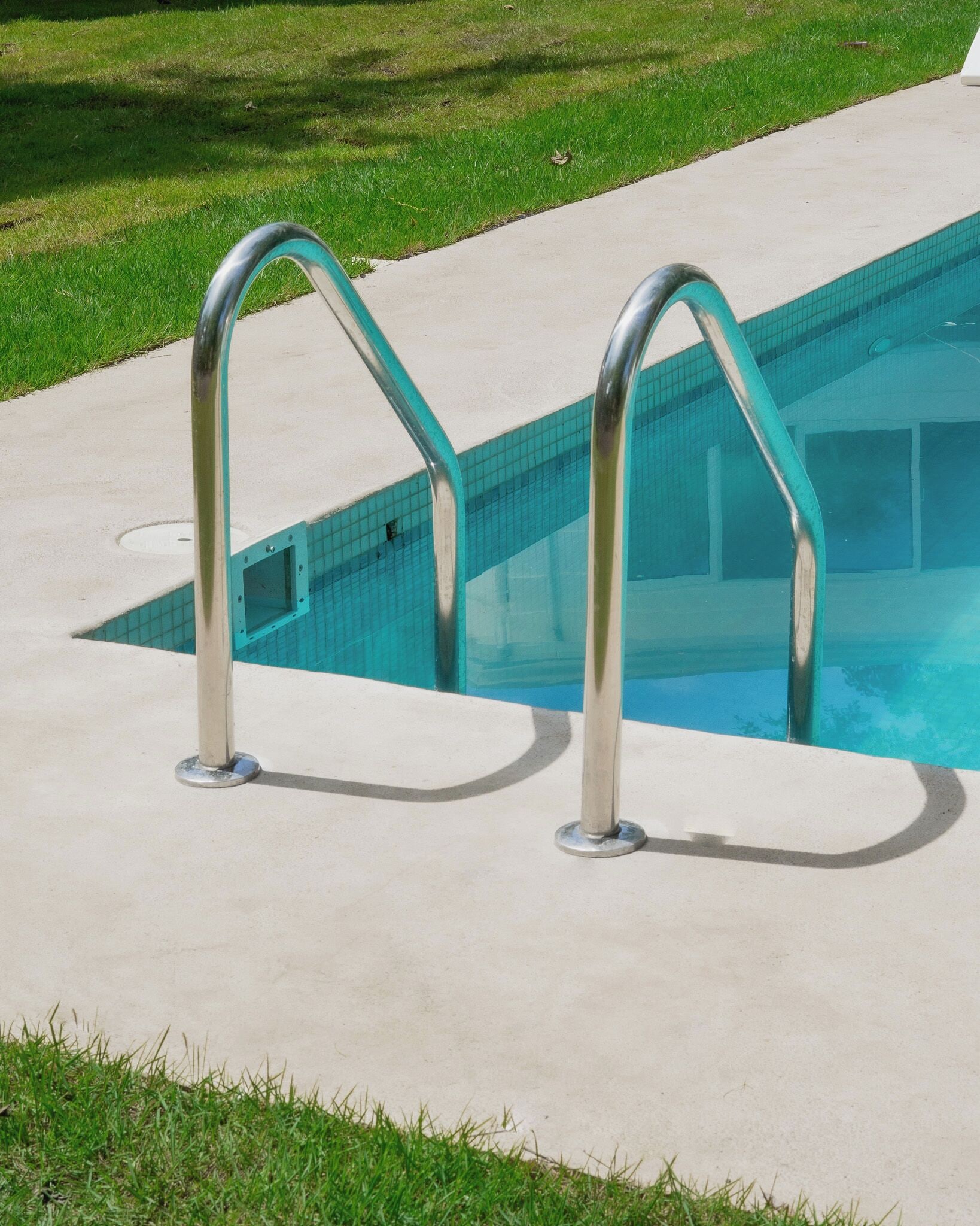 Una piscina amb dues baranes metàl·liques.