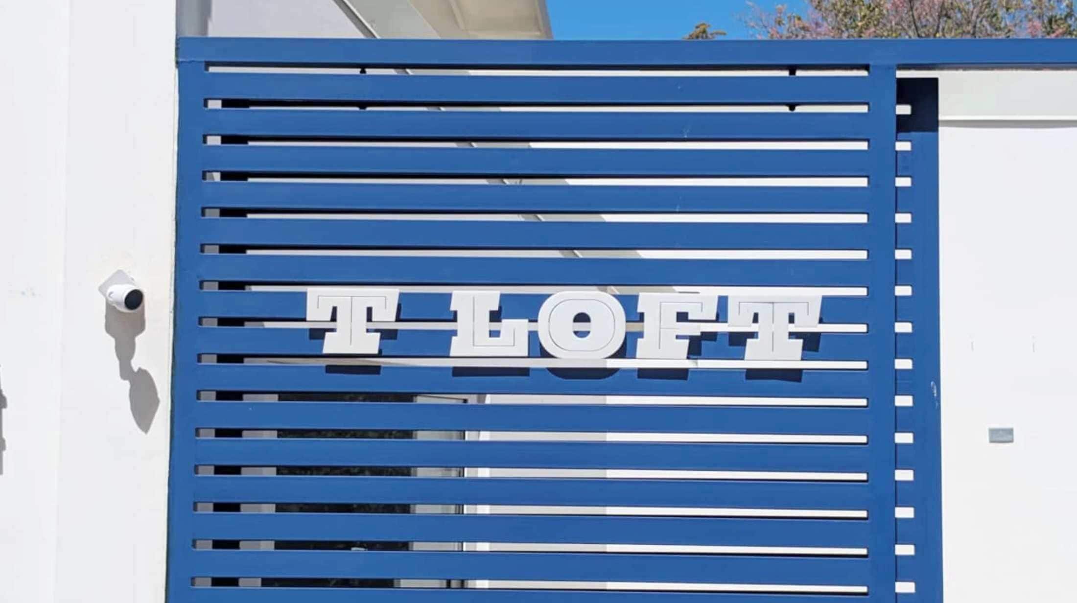 En blå port med bokstäverna ”T LOFT” som anger namnet på stället.