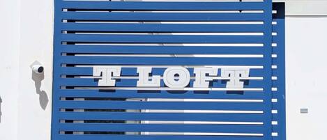 En blå port med bokstäverna ”T LOFT” som anger namnet på stället.