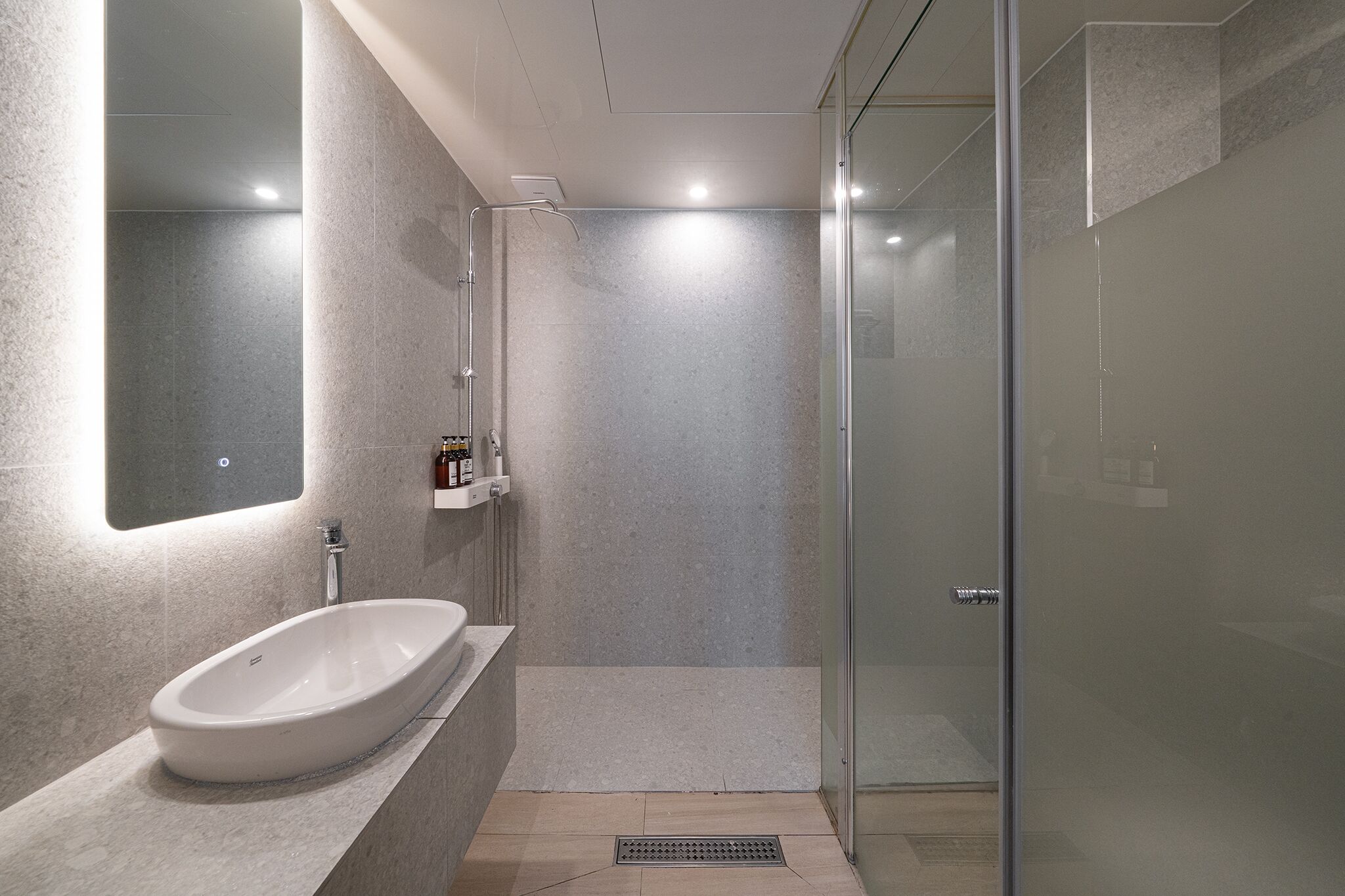 A modern bathroom with a freestanding bathtub, a glass shower enclosure, and a wall-mounted mirror.
