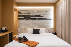 A modern hotel room with a large bed, a wooden nightstand, a marble headboard, and a wall-mounted artwork depicting a mountainous landscape. - Incheon Brown-Dot Hotel (Incheon)