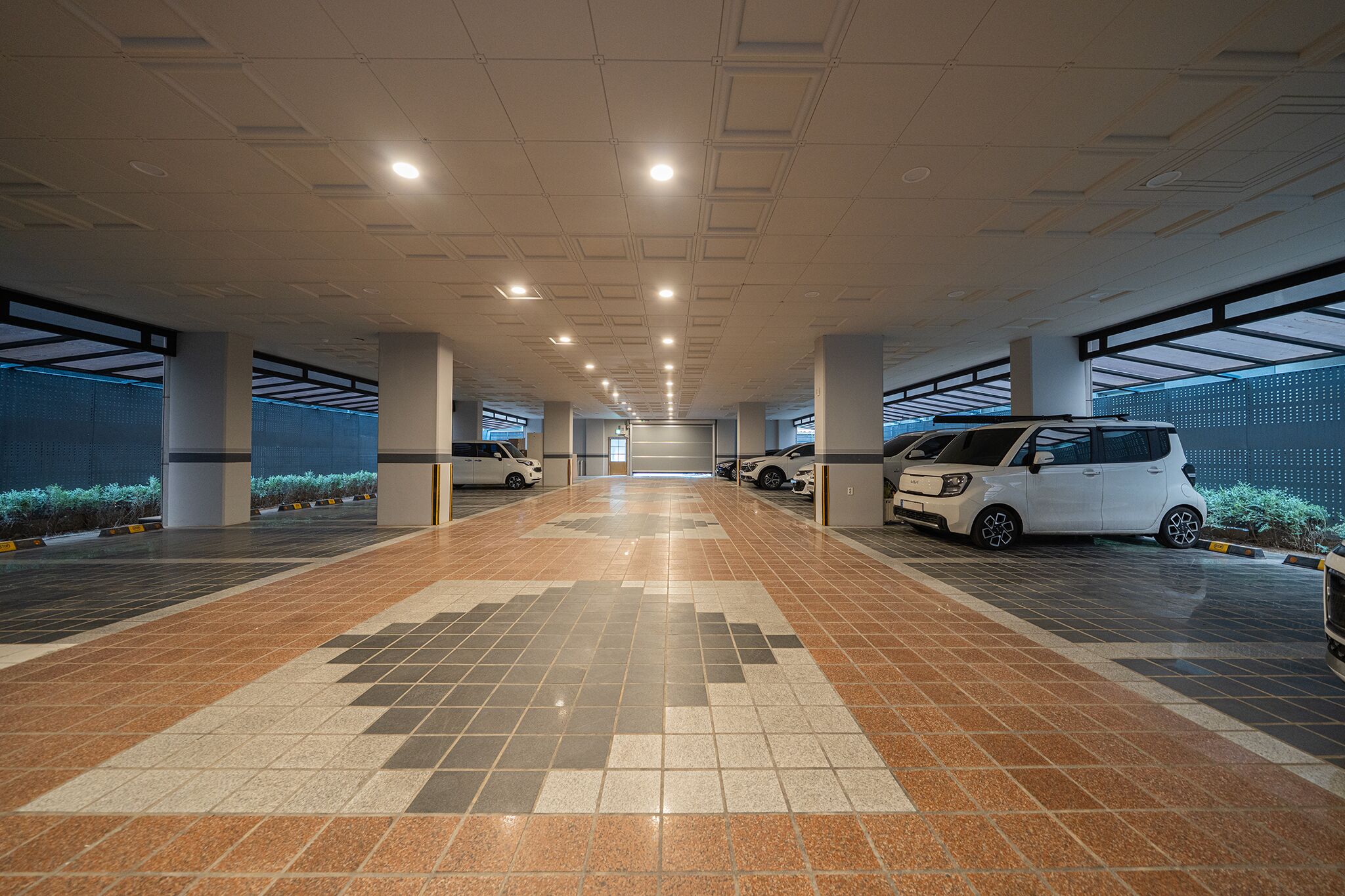 Un estacionamiento con varios niveles, amplias pasarelas y varios vehículos aparcados.