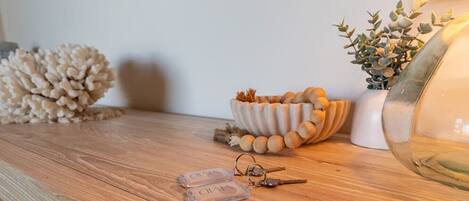 A wooden table with a decorative bowl, a lamp, and a small plant.