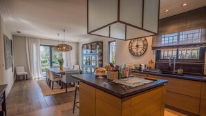 Una cocina moderna con una isla central, armarios empotrados y un ventanal grande.