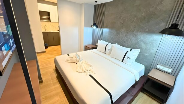 A modern hotel room with a large bed, a bedside table, a nightstand, a wall-mounted lamp, and a built-in TV. - Seeds Hotel Bukit Bintang (Kuala Lumpur)