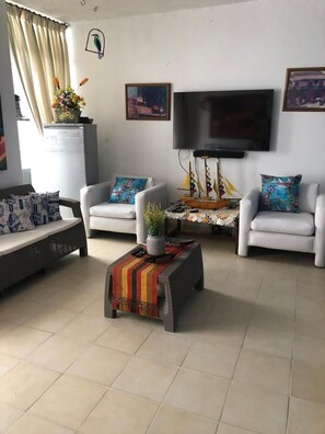 Relax in comfort with a sofa set, flat-screen TV, and decorative touches.