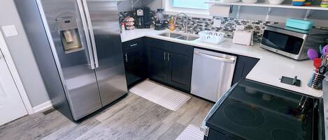 A modern kitchen with stainless steel appliances, a dishwasher, and a microwave.