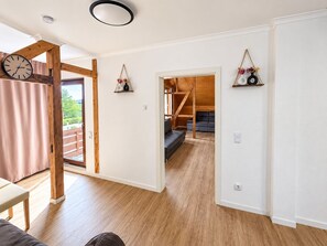 A modern interior with wooden flooring, a sofa, a bench, and a clock. - Our resin dream (Blankenburg (Harz))
