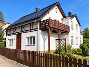 A two-story house with a sloped roof, a wooden deck, and a fenced yard. - Our resin dream (Blankenburg (Harz))