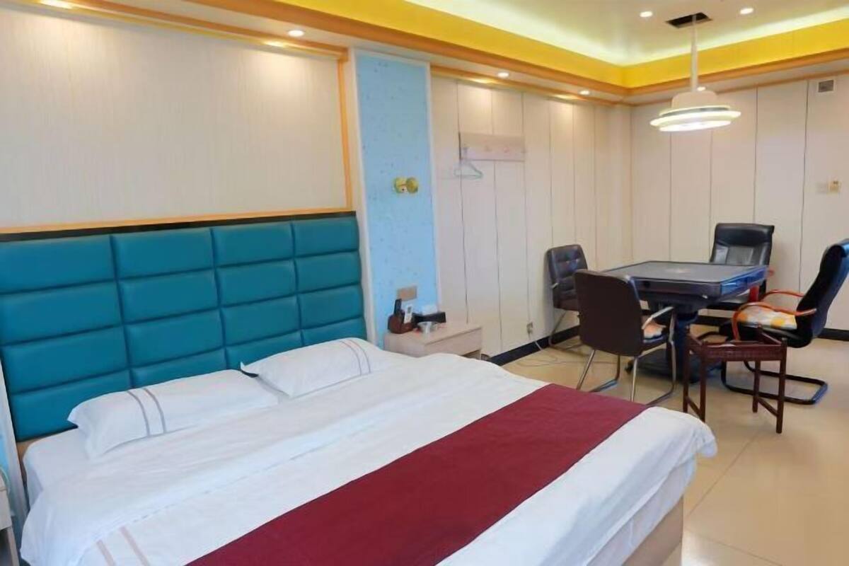 A hotel room with a bed, a desk, and a chair.