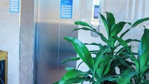 Ένας ανελκυστήρας με ψηφιακή οθόνη και μια μπλε πινακίδα με λευκά γράμματα.