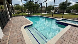 A swimming pool with a tiled edge and a brick patio area. - Spacious 7-bedroom house in Champions Gate (Four Corners)