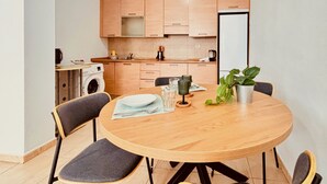 Una cocina moderna con armarios de madera, una mesa redonda con sillas y una planta en maceta.