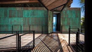 A modern building with a wooden deck and metal railings. - Kelapa House (Koh Samui)