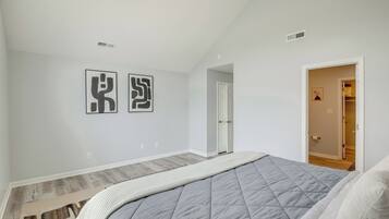 Une chambre à coucher avec un lit, un tapis et deux œuvres d’art murales.