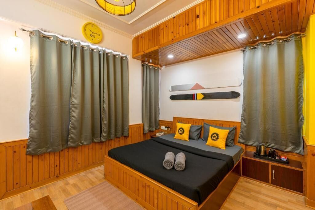 A bedroom with a wooden bed, green curtains, a clock on the wall, and a ski board decoration.