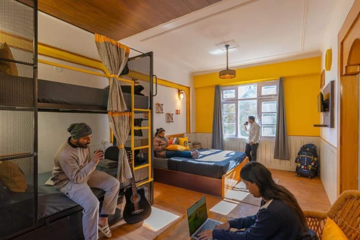 A compact room with bunk beds, a desk, and a laptop.