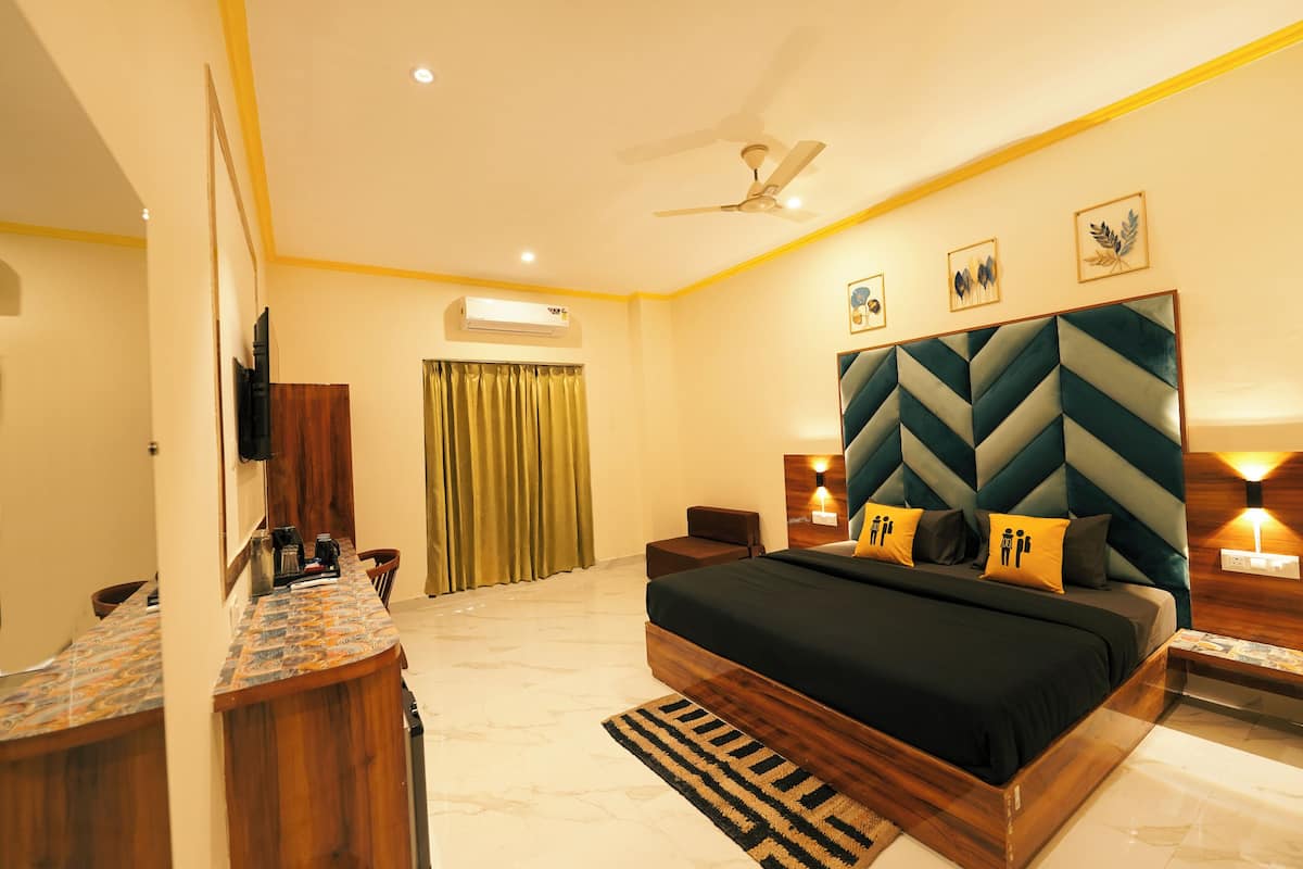 A modern hotel room with a large bed, a desk, and a vanity.