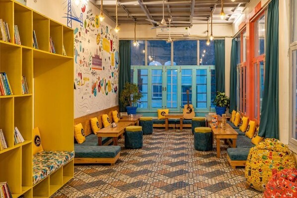 A cozy reading area with a bookshelf, seating, and a patterned floor.