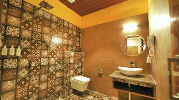 Un baño con pared de azulejos, un lavabo, un espejo y un inodoro.