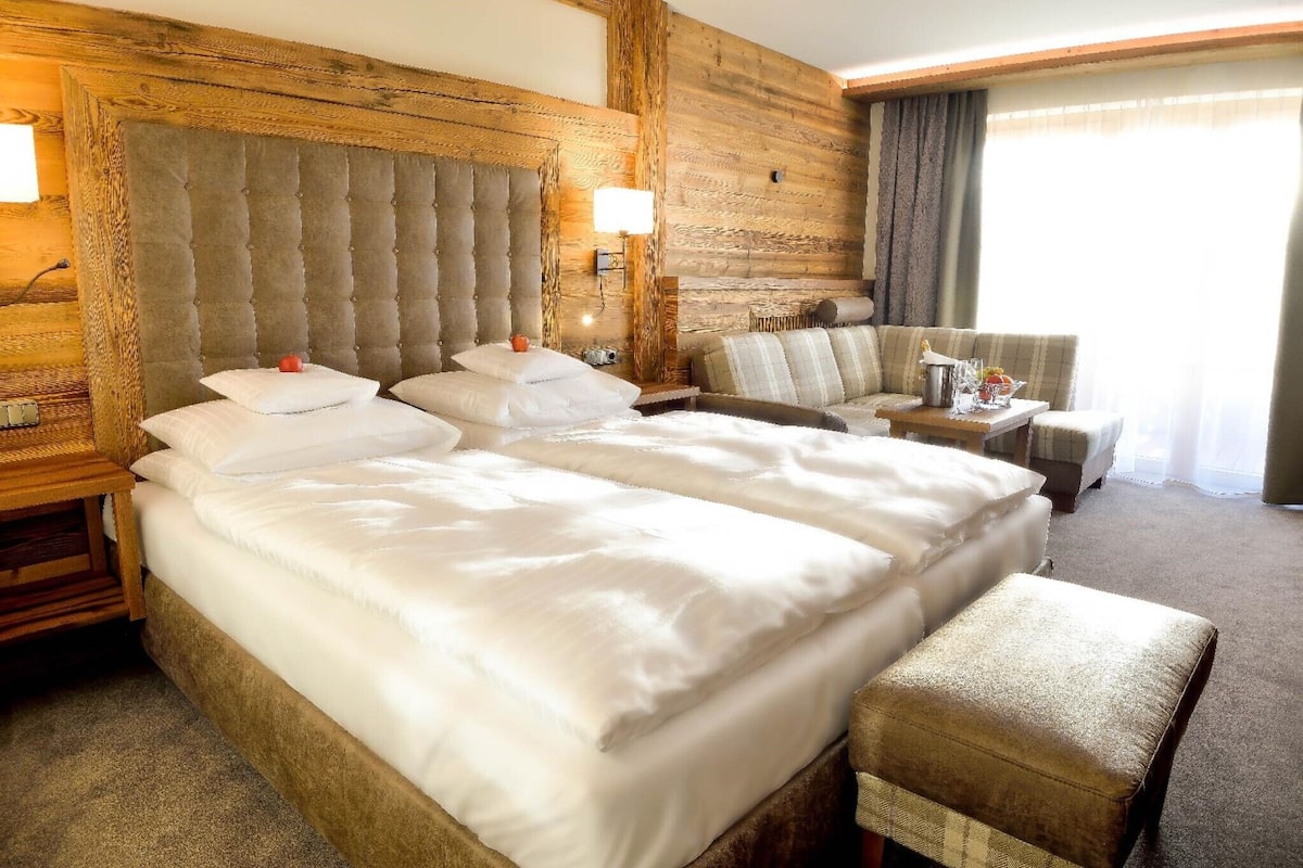 Et hotelværelse med en stor seng, en sofa og et lille bord.