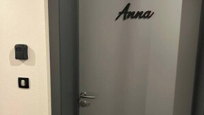 A door with the name "Anna" and the number "110" on it, a door handle, and a small black object on the wall to the left. - Studio Anna near Mulhouse (Wittelsheim)