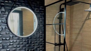 A modern bathroom with a round mirror, a stone sink, and a shower enclosure. - Studio Anna near Mulhouse (Wittelsheim)