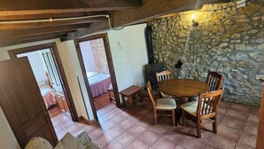Un comedor acogedor con pared de piedra, muebles de madera y chimenea.