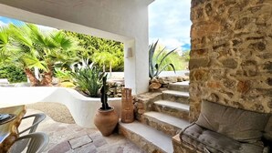Un patio con escalones de piedra, un espacio de descanso y vistas a zonas verdes.