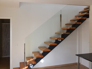 A modern staircase with wooden steps and glass railings. - Villa in Moraira with Pool near Beach (Moraira)