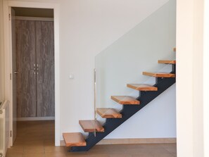 Una escala moderna amb graons de fusta i barana de vidre.