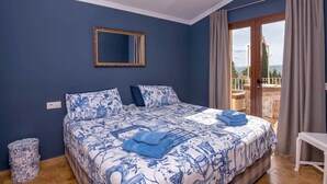 A bedroom with a large bed, a mirror, and a view of the outside. - Villa near Montgó with Pool and Beach (Javea)