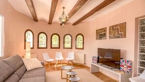 A living room with a sofa, chairs, a TV, and artwork on the wall. - Villa near Montgó with Pool and Beach (Javea)